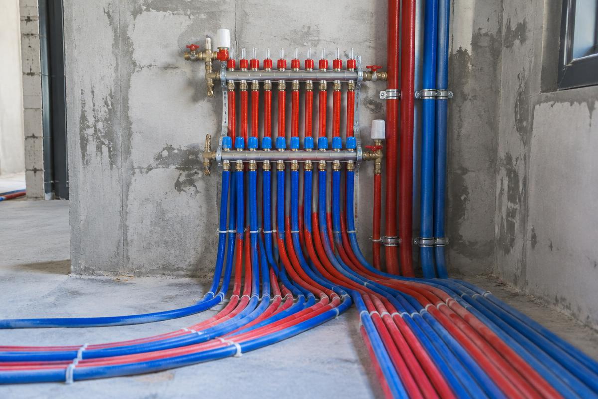 Réseau de plomberie neuf avec collecteur et tubes multicouches dans une maison en construction